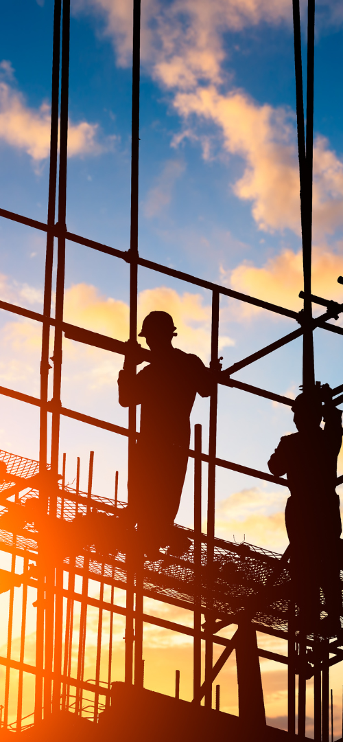 Construction workers on framing at sunset
